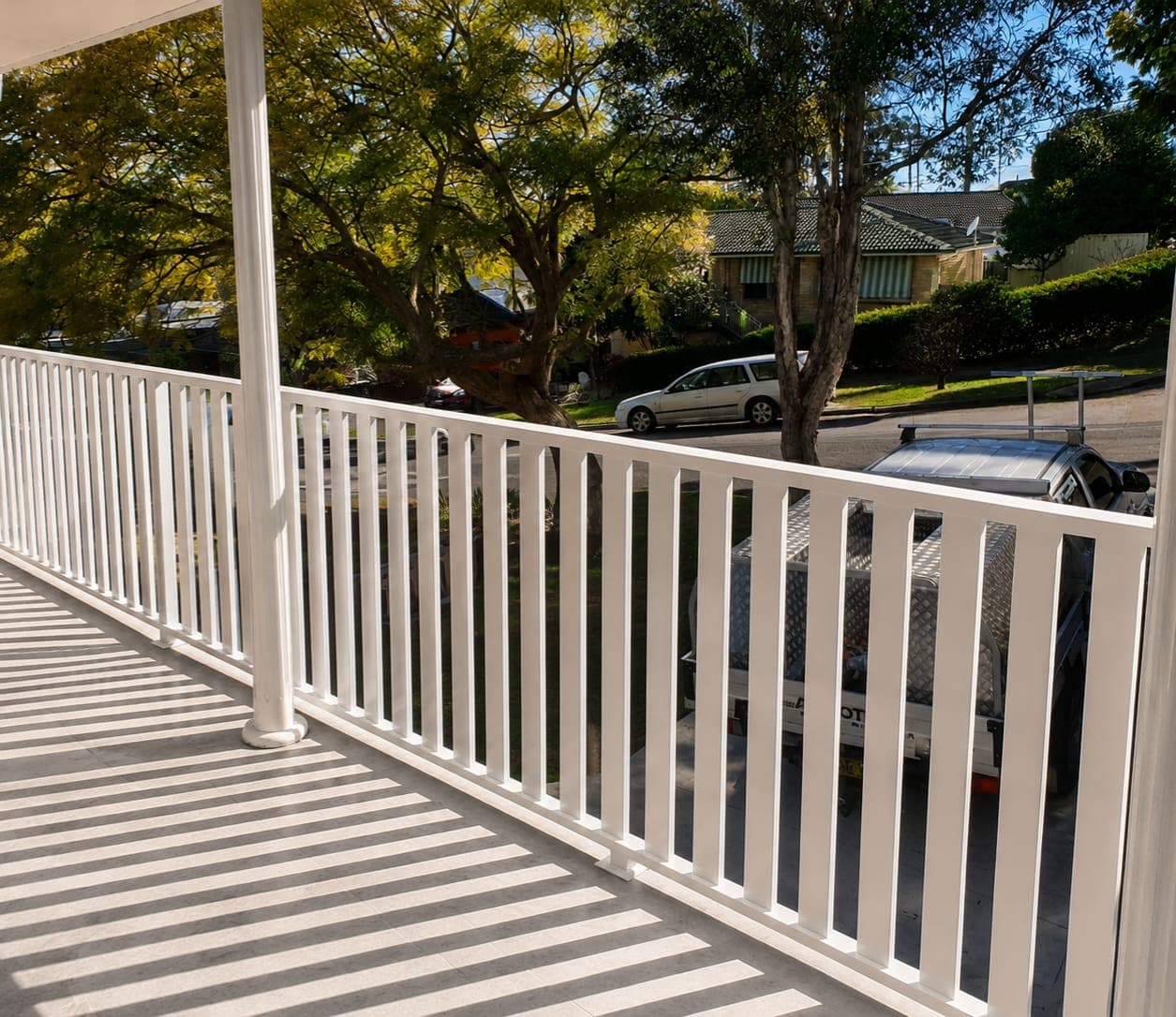 White powder-coated metal slat balustrade on a residential balcony