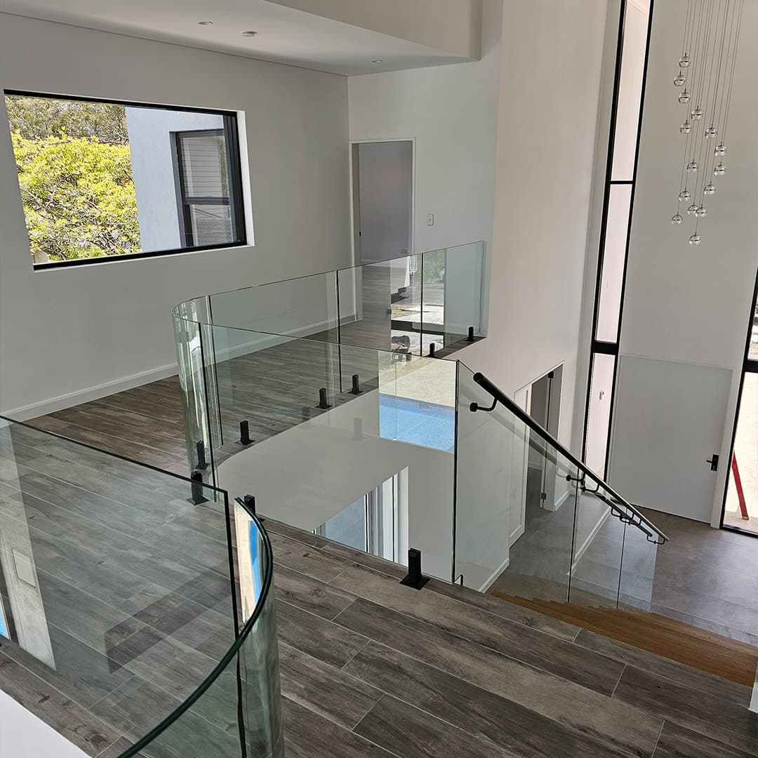 Frameless glass balustrade with black spigots on a stair landing