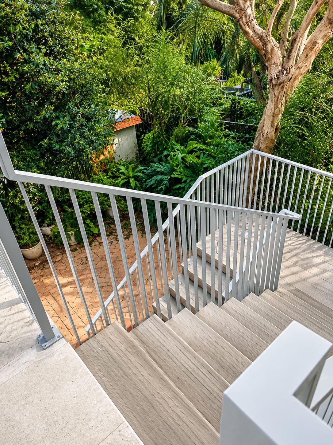 Custom powder-coated metal handrail on an outdoor garden staircase